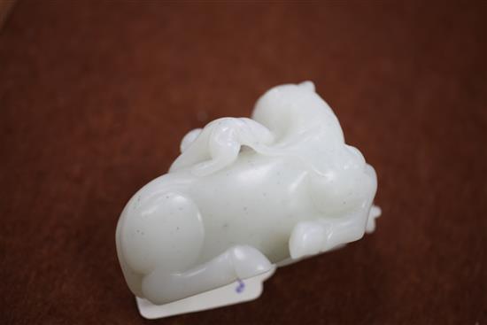 A Chinese white jade carving of two monkeys clambering on a recumbent horse, 20th century, 9cm, wood stand